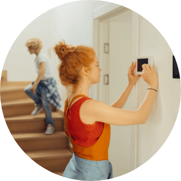 girl with curly red hair using a thermostat